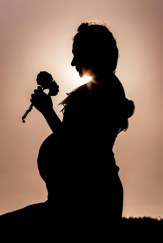 Pregnant woman in front of susnset