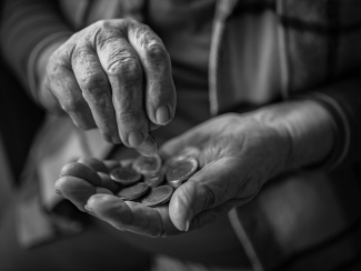 Hands of a retiree counting pennies.